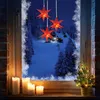 A festive Christmas scene viewed through a window, with red star lights hanging inside and a snowy landscape outside. Produktbild-Vorschau