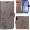 Collage of images showing a grey flip phone case with a floral and butterfly design, featuring card slots and a stand function. Produktbild-Vorschau