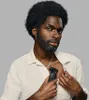 A man is holding a grooming device to his chest. Produktbild-Vorschau