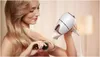 A woman is drying her hair with a hairdryer and a brush. Náhled obrázku produktu