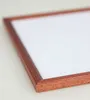 A close-up, angled view of a wooden picture frame with a white insert, set against a plain white background. Produktbild-Vorschau