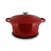 A red Dutch oven sits on a black trivet against a white background. Podgląd zdjęcia produktu