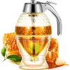 A honey dispenser with a honeycomb pattern, filled with honey, sits next to honeycomb pieces and leaves. Produktbild-Vorschau