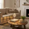 A cozy living room scene with a sofa, coffee table, and fireplace. Produktbild-Vorschau