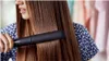 A woman is straightening her hair with a Philips hair straightener. Voir les images du produit