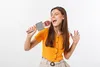 A young woman is singing into a karaoke microphone. Produktbild-Vorschau