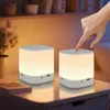 A hand is shown touching a bedside lamp on a nightstand, with another lamp in the background. Voir les images du produit