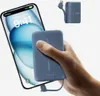 A hand holds a blue power bank next to a smartphone that is charging. Produktbild-Vorschau