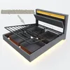 A modern upholstered bed frame with its storage drawers exposed and the lift-up mechanism partially open, showcasing the hydraulic lift system and storage capacity. It features integrated LED lighting in the headboard. Náhled obrázku produktu