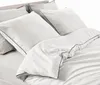 A close-up view of white bedding with navy blue piping. Produktbild-Vorschau