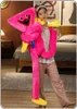 A person is holding a large pink plush toy in a bedroom setting. Produktbild-Vorschau