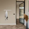 A wall-mounted coat rack with a jacket hanging on it, next to an open door. Anteprima dell’immagine prodotto