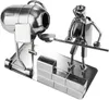 A metal figurine of a construction worker operating a cement mixer, with a brick wall in the foreground. Náhľad obrázku produktu