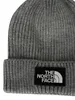 A close-up view of a gray knitted beanie with a black patch featuring the North Face logo. Produktbild-Vorschau
