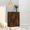 A shoe cabinet with a wood grain finish is shown in a hallway next to a white door. A small white ottoman and a rug are on the floor in front of the cabinet. A pendant light hangs from the ceiling above. Náhled obrázku produktu