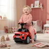 A baby is riding a red toy car in a nursery. Produktbild-Vorschau