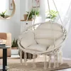 A hanging chair with cushions in a living room setting. Voir les images du produit