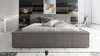 A modern bedroom with a large bed, artwork on the wall, and minimalist furniture. Produktbild-Vorschau