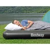 A woman sleeping on an inflatable mattress by a lake with a tent in the background. Náhled obrázku produktu