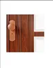 A close-up view of a wooden door with a handle and lock. Produktbild-Vorschau