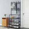 A black metal coat rack with shoe shelves in a room next to a wooden dresser and a white door. Produktbild-Vorschau