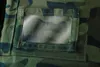 A close-up view of a camouflage fabric pocket with a clear plastic window. Náhled obrázku produktu