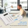 A man is working at a desk with a white corded phone in the foreground. Náhľad obrázku produktu