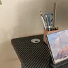 A close-up view of a desk surface with office supplies and a laptop. Náhled obrázku produktu