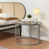 A bedside table with a lamp, a book, and a cup of coffee next to a bed with a cane headboard. Produktbild-Vorschau