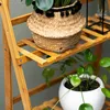 A close-up view of a multi-tiered wooden plant stand with plants on it. Produktbild-Vorschau