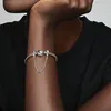 A close-up shot of a person's arm wearing a silver Pandora bracelet with a safety chain adorned with blue and teal stones. Anteprima dell’immagine prodotto