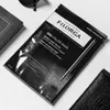 A black and white flat lay of a Filorga Time-Filler Mask, along with a notebook and a wallet. Anteprima dell’immagine prodotto