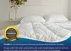 A neatly made bed with white bedding and pillows, with a decorative plant on a shelf in the background. Produktbild-Vorschau