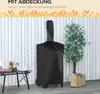 A pizza oven covered by a black protective cover, standing next to a potted plant and a small table with items on it, against a white wooden wall. Produktbild-Vorschau