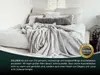 A bed with a light gray blanket draped over it, with pillows in the background. Produktbild-Vorschau