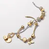 A collection of gold and silver charm bracelets with various charms. Produktbild-Vorschau