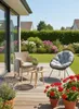 A sunny patio with outdoor furniture and blooming flowers. Anteprima dell’immagine prodotto