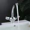 A chrome faucet with water running into a white sink, with dark green leaves in the background. Produktbild-Vorschau