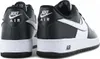 A close-up, rear-facing view of two black and white Nike Air Force 1 Low '07 sneakers. Anteprima dell’immagine prodotto