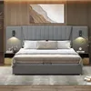 A modern bedroom with a large upholstered bed as the focal point. Produktbild-Vorschau