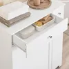 A white storage cabinet with drawers and doors, containing towels, a soap dish, and a basket with sponges. Náhľad obrázku produktu