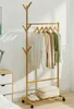 A bamboo garment rack with clothes hanging on it, placed in a room with a dresser and bed visible. Produktbild-Vorschau