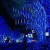 A pathway lined with trees decorated with blue LED lights. Produktbild-Vorschau