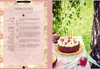 A recipe page from a cookbook with a cake on a table in the background. Produktbild-Vorschau