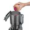 A hand is shown placing a beet into a slow juicer. Náhled obrázku produktu
