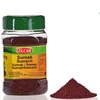 A bottle of Gülcan Sumak spice and a pile of the spice next to it, on a white background. Produktbild-Vorschau