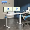 A white FlexiSpot standing desk with dual monitors, headphones, and a chair in a modern home office setting. Podgląd zdjęcia produktu