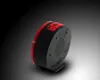 The underside of a black and red alarm clock with a speaker grille and buttons. Voir les images du produit