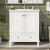 A white bathroom vanity with two doors and a drawer, set against a green tiled wall. Anteprima dell’immagine prodotto