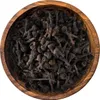 A close-up, top-down view of dried cinnamon buds in a wooden bowl. Produktbild-Vorschau